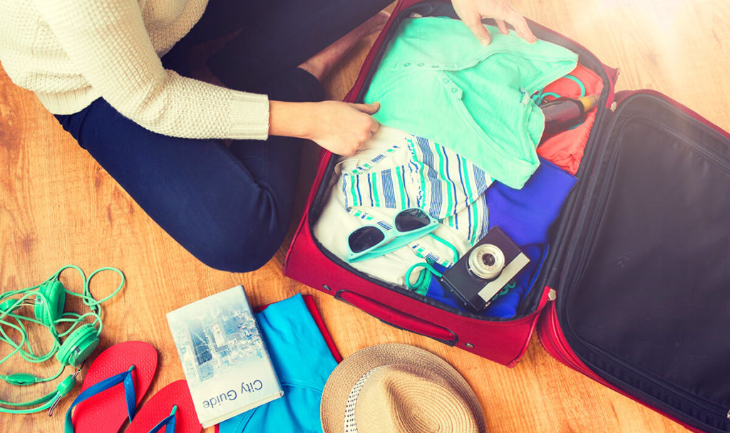 woman packing travel bag for vacation